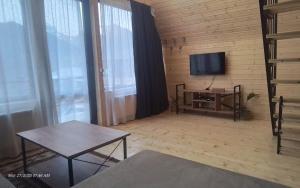 a living room with a television and a table at Rocky Views in Kazbegi