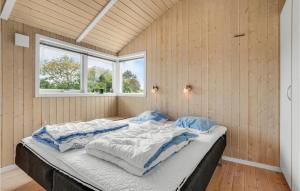 ein großes Bett in einem Zimmer mit zwei Fenstern in der Unterkunft 4 Bedroom Gorgeous Home In Brkop in Børkop