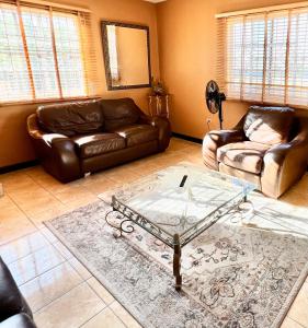a living room with couches and a glass table at 2 Bed Apartment at the Hideaway in St Mary