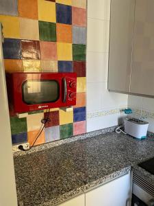 a red microwave sitting on top of a kitchen counter at Apartamento Puertomar in Roquetas de Mar