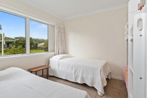 een slaapkamer met 2 bedden en een raam bij Matapouri Family Retreat - Matapouri Holiday Home in Matapouri