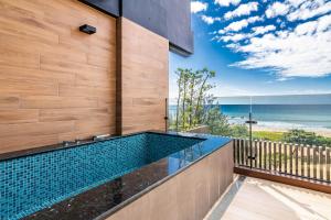a swimming pool on the side of a house with the beach at Kenting Sea Wall 112 in Kenting