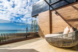 墾丁的住宿－墾丁海堤112海景別墅，俯瞰大海的阳台的藤椅