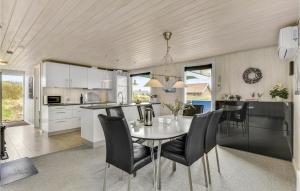 a kitchen and dining room with a table and chairs at Holiday Home Fyrmarken Hvide Sande in Nørre Lyngvig +26 photos