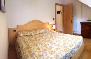 a bedroom with a large bed with a floral bedspread at Ciasa Bocter in Moena