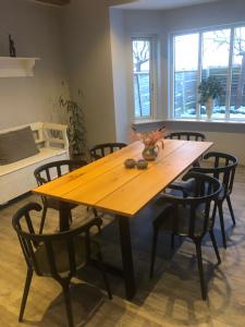 - une table en bois avec des chaises dans une chambre avec un lit dans l'établissement VV Apartments 50, à Ringsted