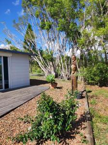 une statue dans une cour à côté d'une terrasse en bois dans l'établissement Chambres d'hôtes Tontouta Tamoa, à Païta