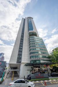 a tall building with cars parked in front of it at LILA SUITES ONE BUKIT CEYLON in Kuala Lumpur