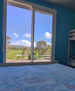 1 dormitorio con cama y ventana grande en Chambres d'hôtes Tontouta Tamoa, en Païta