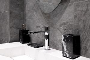um lavatório de casa de banho com uma torneira e um espelho em Studio Quartier Champs Elysées 1 em Paris