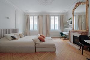 a white living room with a couch and a mirror at Studio Quartier Champs Elysées 1 in Paris