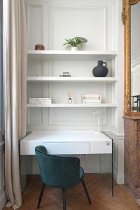 - Escritorio blanco con silla verde en una habitación en Studio Quartier Champs Elysées 1, en París