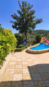 a swimming pool with a tree and a slide at Casa Vacanze Salvatore-Relax con piscina privata in Palazzolo Acreide