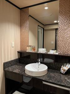 a bathroom with a sink and a large mirror at HOTEL Shuffle in Tokyo