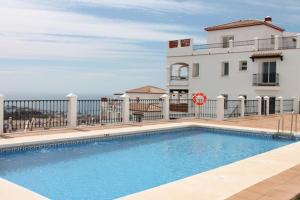 a swimming pool in front of a house and a building at Apartment in Las Palmeras de Calahonda in Mijas Costa