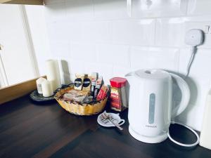 a counter with a coffee maker and a basket of food at Spacious Flat In a Victorian House - Free Parking in Bradford