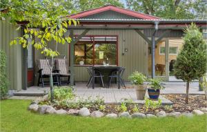 a patio with a table and chairs in a yard at Holiday Home Østersvej Glesborg X in Fjellerup Strand