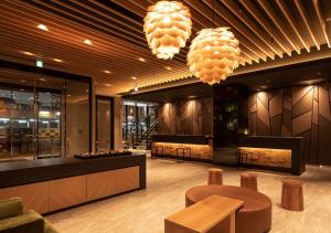 a lobby with two chandeliers and a table and chairs at Tokyu Stay Sapporo Odori in Sapporo
