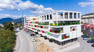 a white building with colorful windows on a street at Modern Apartment in Zenica in Zenica