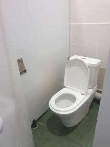 La salle de bains est pourvue de toilettes blanches. dans l'établissement Fox Hostel, à Almaty