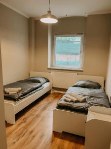 2 camas en una habitación con ventana en Gemütliche 93m² Wohlfühlfläche mit Ausblick zum Weltkulturerbe!, en Essen
