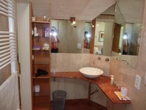dwie osoby robiące zdjęcia łazienki z umywalką w obiekcie Apartment Leonardo w mieście Bolzano