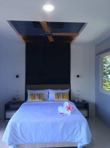 een slaapkamer met een wit bed en een zwarte muur bij The Lighthouse in Puerto Galera