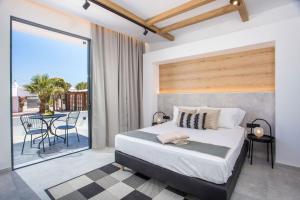 a bedroom with a bed and a balcony with a table at cactus suites in Faliraki