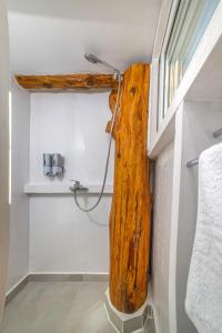 a bathroom with a shower with a wooden beam at Green Leaf in Vanáton