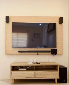 TV de pantalla plana colgada en la pared en Studio Type - Matina Enclaves Residences en Dávao