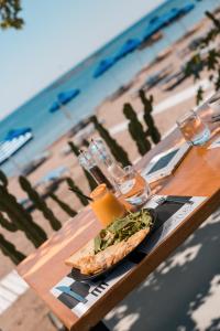 a table with a sandwich and glasses of orange juice at cactus suites in Faliraki