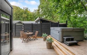 una terraza con bañera de hidromasaje, mesa y sillas en Gorgeous Home In Haderslev With Kitchen, en Haderslev