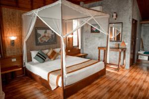 1 dormitorio con 1 cama con dosel en Sensi Paradise Beach Resort, en Ko Tao