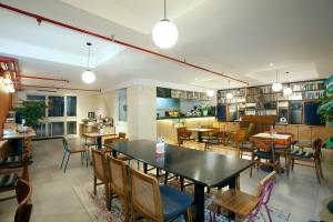 Liberta Hub Blok M Jakarta في جاكرتا: غرفة طعام مع طاولات وكراسي في مطعم