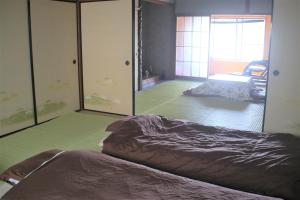Postel nebo postele na pokoji v ubytování ゲストハウスさくら Guesthouse Sakura
