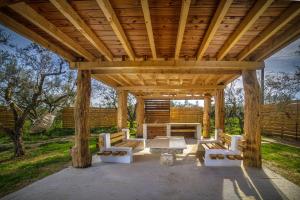 a wooden pavilion with a picnic table and benches at Green Leaf in Vanáton