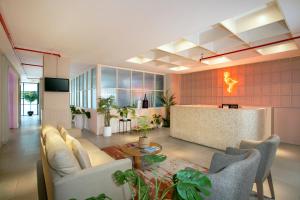 a lobby with a couch and chairs and a bar at Liberta Hub Blok M Jakarta in Jakarta