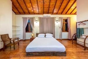 ein Schlafzimmer mit einem Bett und einem Stuhl darin in der Unterkunft Kalugal Nivasa in Colombo