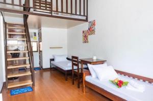 a living room with a loft bed and a table at Teteng's Apartelle in San Vicente +44 photos