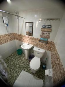 a bathroom with a toilet and a sink at Teteng's Home in San Vicente