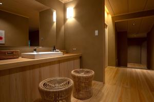 a bathroom with a sink and two wicker stools at Tsukihitei in Nara