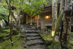 a stone path leading to a house with trees at Tsukihitei in Nara