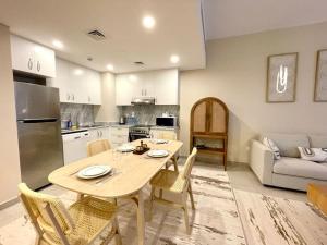 a kitchen and living room with a table and chairs at Dar Vacation - Modern Luxury 1BR Apartment in MJL in Dubai