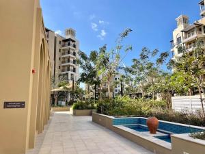 a walkway with a pool in the middle of a building at Dar Vacation - Modern Luxury 1BR Apartment in MJL in Dubai