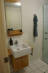 a bathroom with a white sink and a mirror at Clifton Beach Retreat - 2 bed 2 bath apartment in Clifton Beach