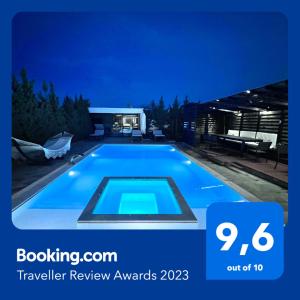 uma piscina azul à noite com uma caravana em Olivujoj Villajoj - Deluxe Villa with Detached Pool House em Anavissos