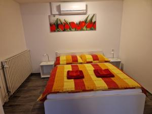 sypialnia z łóżkiem z żółtym i czerwonym kocem w obiekcie Ubytování u Marty BEZ TERASY w mieście Šakvice