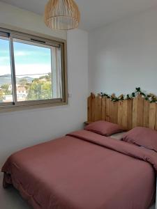 une chambre avec un grand lit avec une fenêtre dans l'établissement T2 vue mer, à Six-Fours-les-Plages