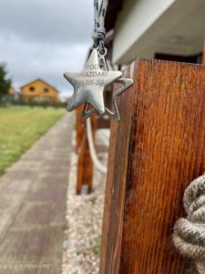 a silver star hanging on a wooden door at Pod Gwiazdami in Władysławowo