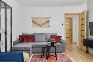 ein Wohnzimmer mit einem grauen Sofa und einem Tisch in der Unterkunft Wrocław City Centre & Main Square Apartment by Renters in Breslau